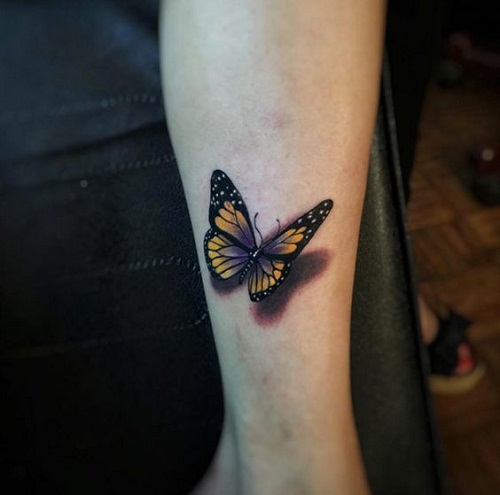 yellow-and-black-with-a-touch-of-violet-butterfly-on-arm-tattoo